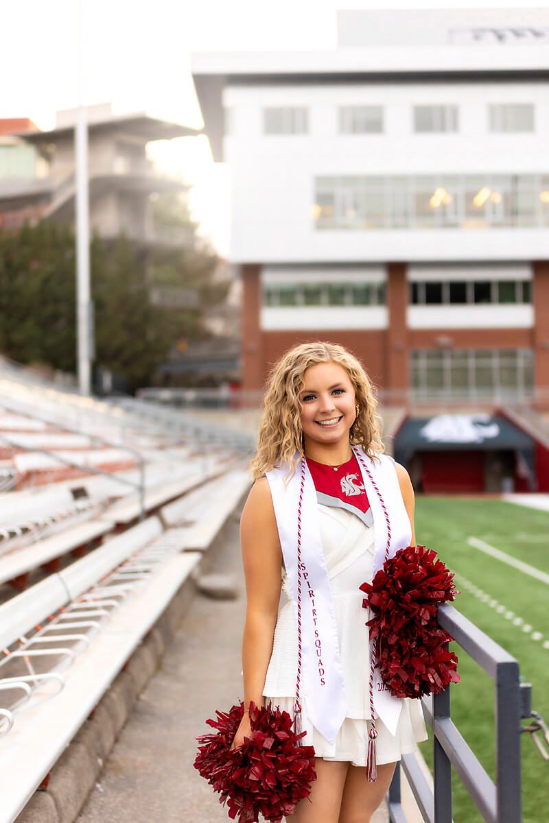 Cheerleader in white dress for college graduation pictures