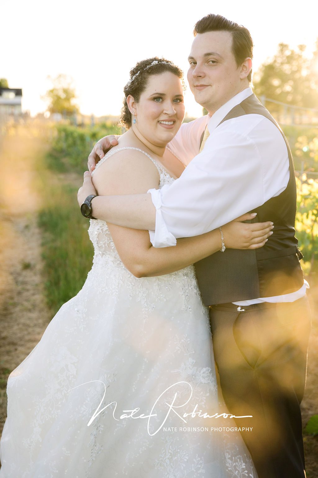 bride and groom hugging in a field at their Belles On The Bluff wedding