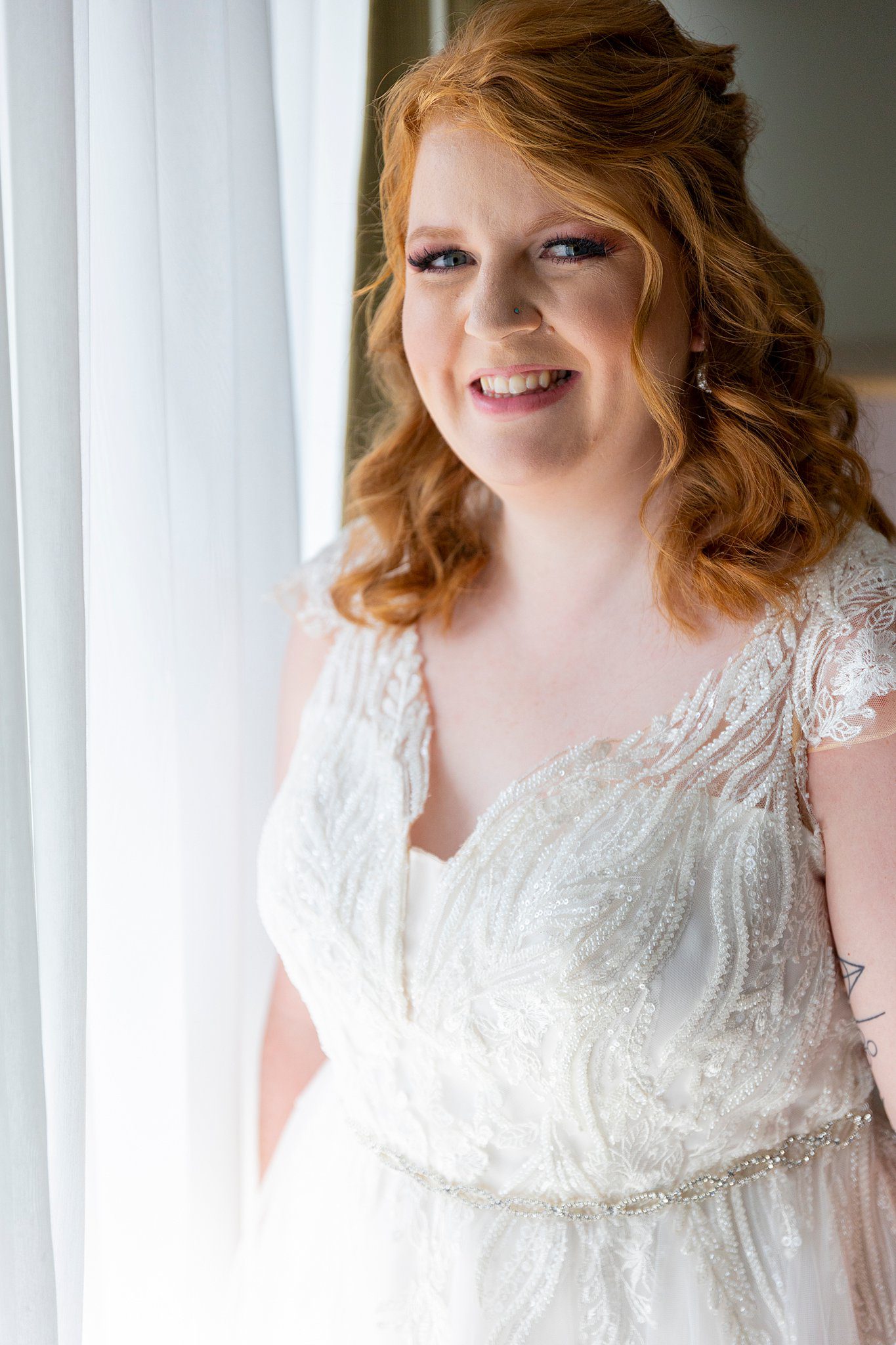 bride in white lace gown standing by a window Lavender Manor wedding
