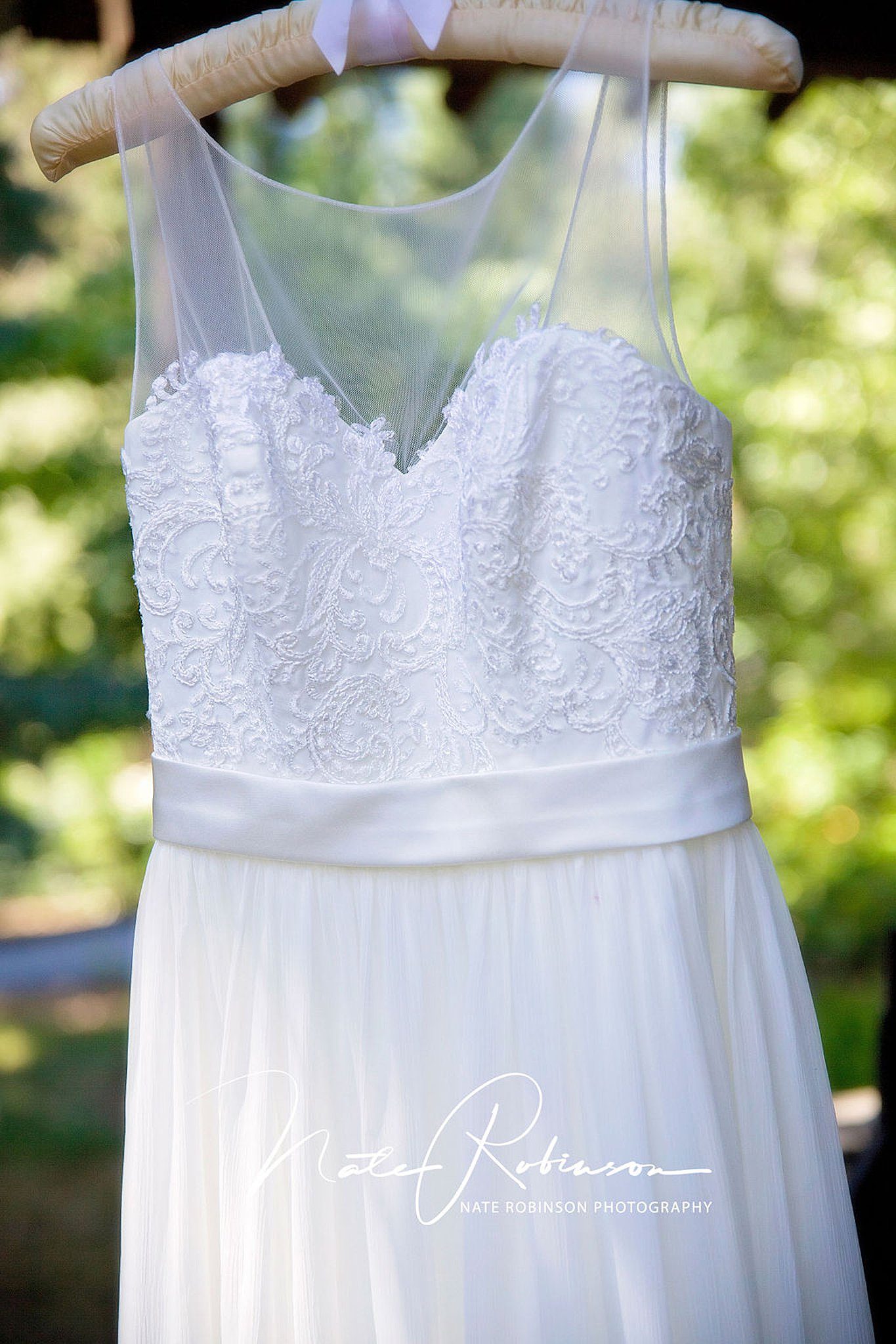 wedding dress hangs outside with velour and lace on a padded hanger at arbor crest wedding