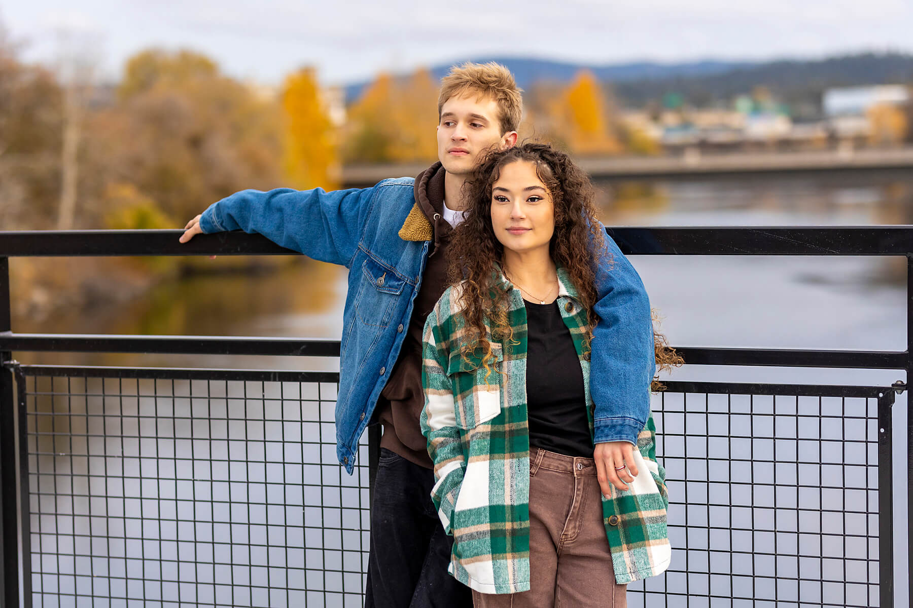 Fall senior portraits of a couple on a bridge over the Spokane river