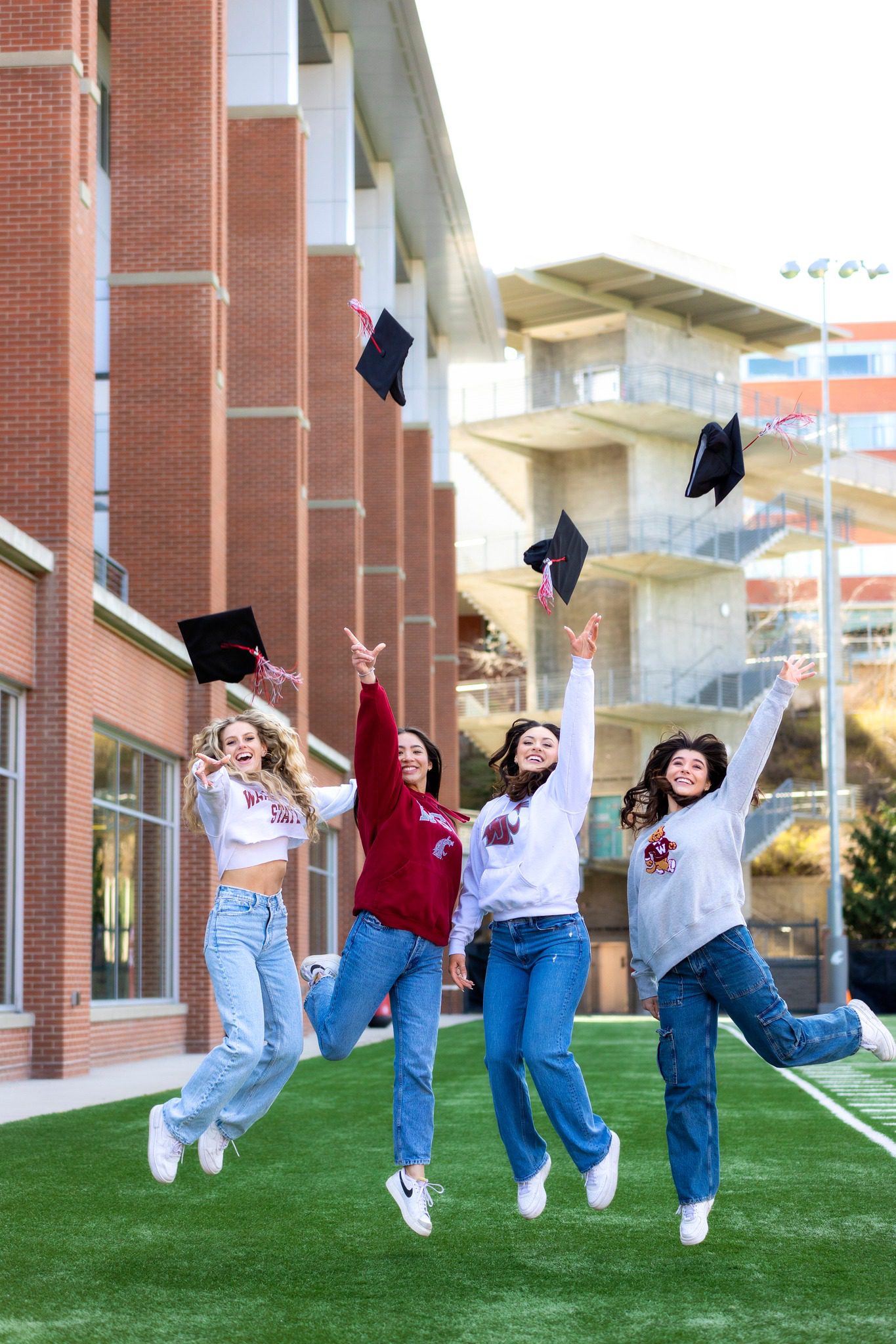 Group of 4 girl grads tossing their caps